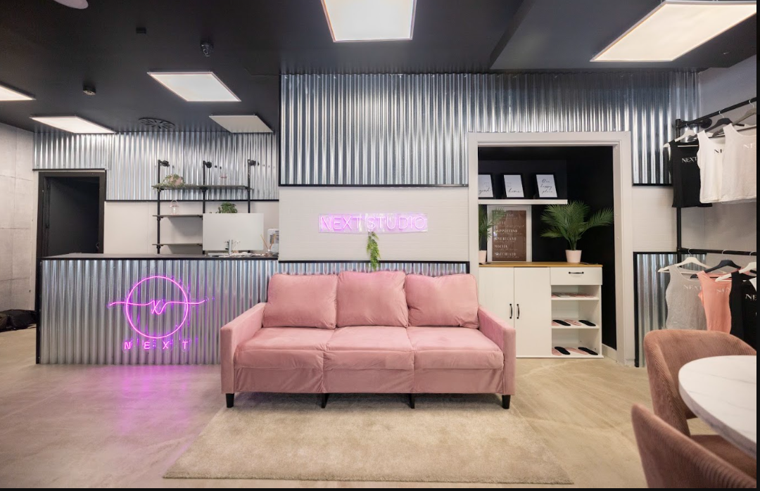 Recepción de NEXT Studio con el neón de la marca y la tienda