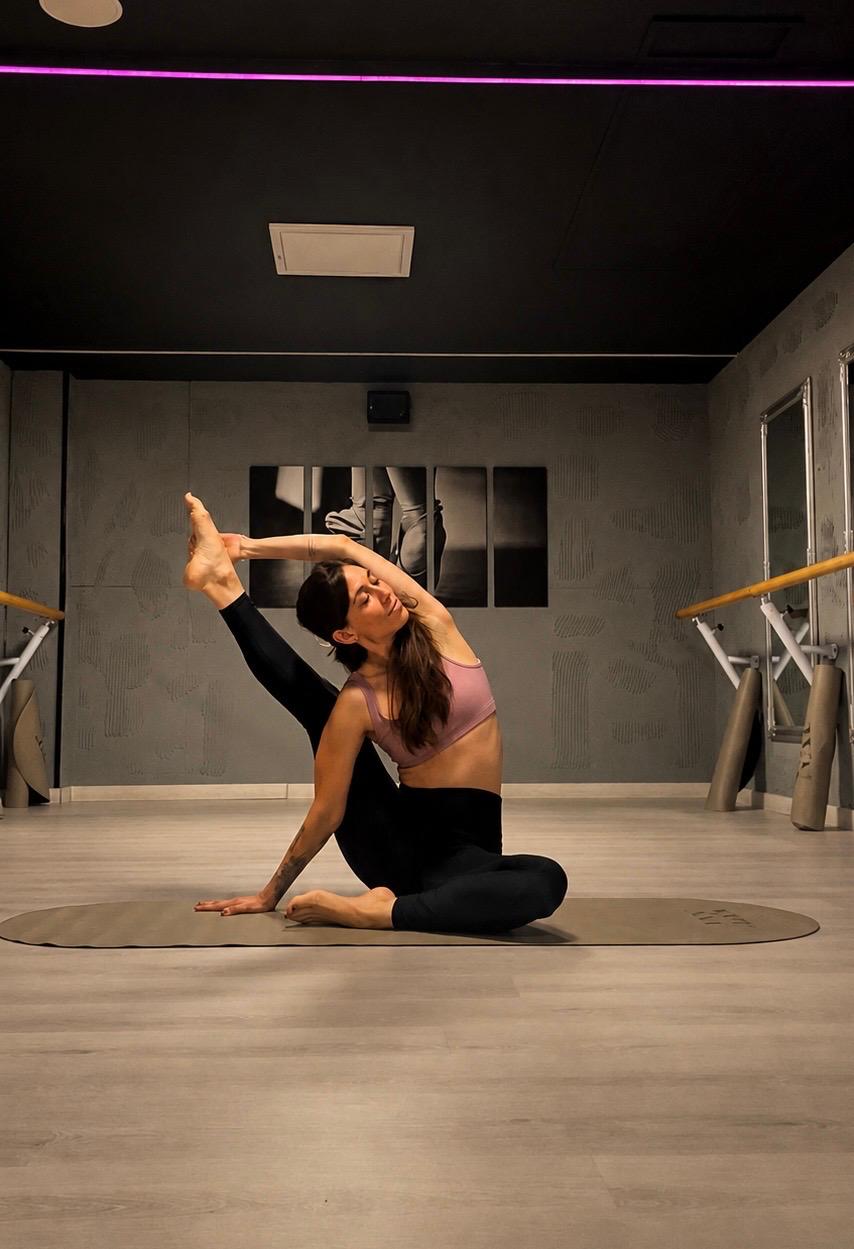 Alumna en postura de yoga sobre la esterilla en NEXT Studio